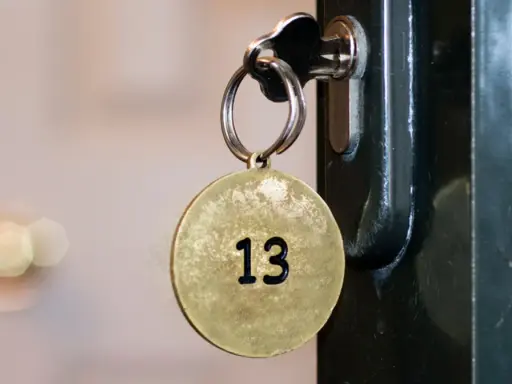 Klucz z okrągłą zawieszką z numerem 13 włożony do zamka.